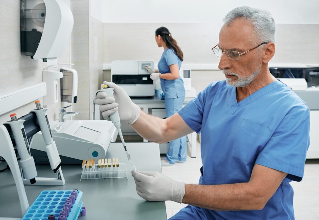 Laboratory technicians working in medical laboratory and researching on blood samples using modern