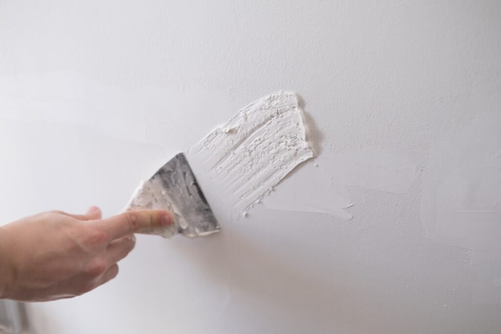 repairing walls with putty and spatula