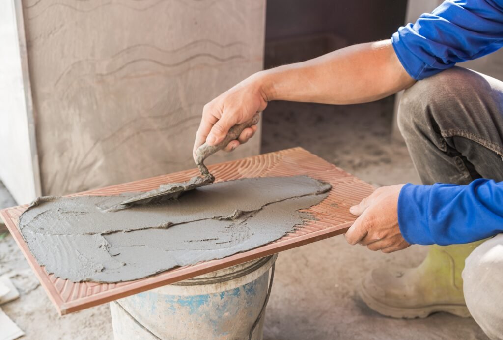 Hand worker tile ceramic installation interior wall kitchen home with trowel cement glue